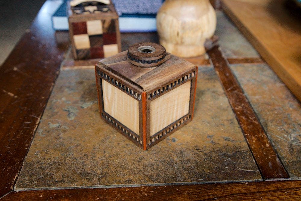 A filmstrip box, walnut and maple, with lens lid handle